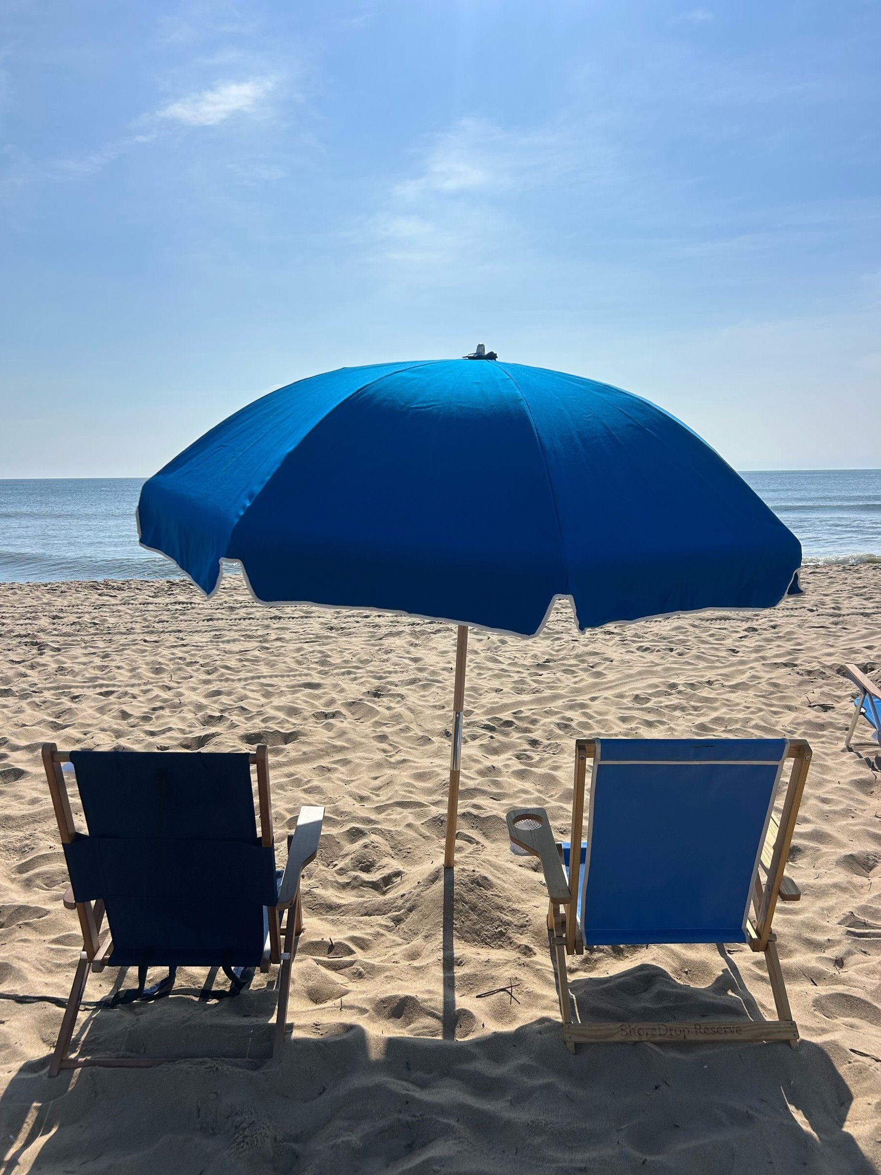 ShoreDrop beach setup with chairs, umbrella, and cooler