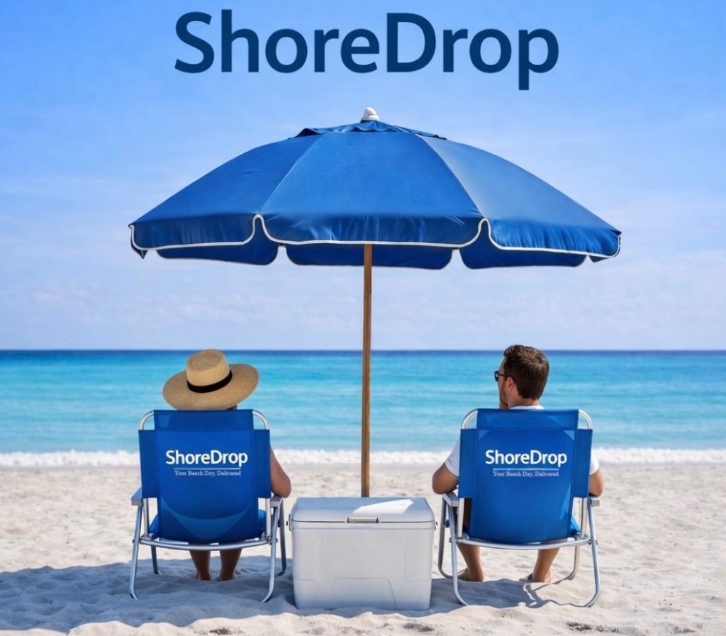 Two guests relaxing in ShoreDrop chairs under a blue umbrella with a cooler between them